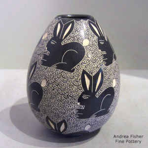 Sgraffito rabbit and mesh motif on a black and white jar