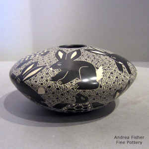 Sgraffito rabbit, turtle and mesh motif on a black and white jar