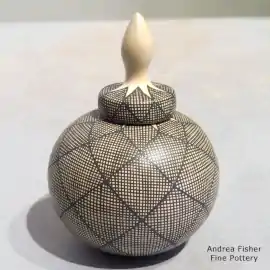 Fine line design on a miniature lidded jar