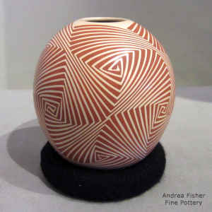 Geometric design in tan on a red jar
