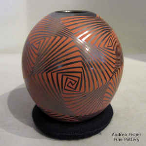 Geometric design in red on a graphite black jar