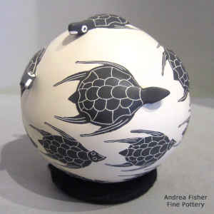 Applique, sgraffito and painted turtle design on a black on buff seed pot