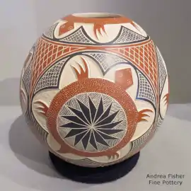 A sgraffito and painted turtle and geometric design on a lightly carved polychrome jar