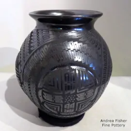 Black-on-black jar with a rolled lip and medallion and geometric design