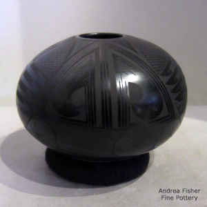 Bird element, fish and geometric design on a black on black jar