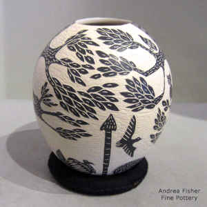 Sgraffito wildlife and nature motif on a black and white jar