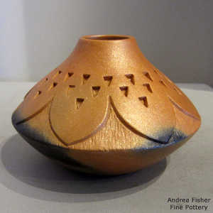 Fire clouds on a golden micaceous jar carved with a geometric design