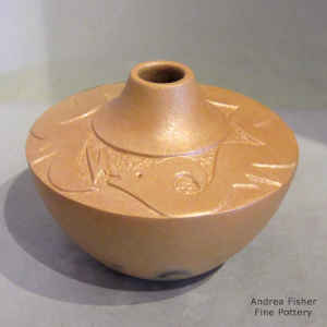 Golden micaceous jar with a sgraffito avanyu design and fire clouds