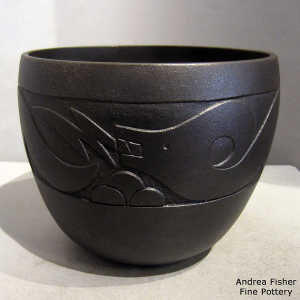 Lightly carved avanyu design and fire clouds on a black micaceous jar
