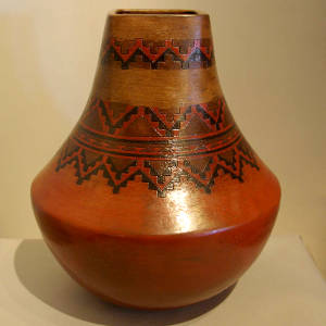 Navajo carpet design on a brown jar with a squarish opening