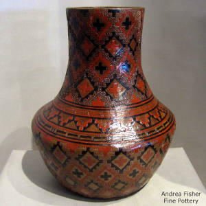 Pine pitch costing on a brown jar decorated with a Navajo carpet design