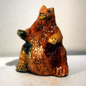 Small brown bear bank coated with pine pitch