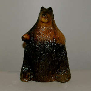 Pinino pone pitch coating on a carved brown bear bank
