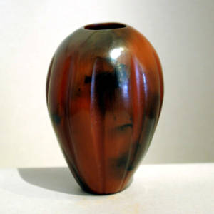 Fire clouds decorate a tall brown melon jar