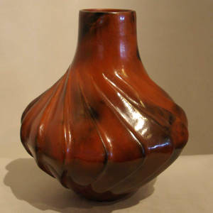 Fire clouds and pine pitch coating on a swirl carved jar