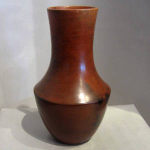 Fire clouds and pine pitch coating on a tall brown vase