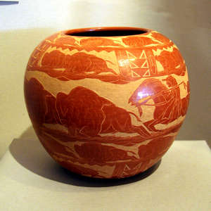Sgraffito buffalo hunt and geometric designs on a red jar