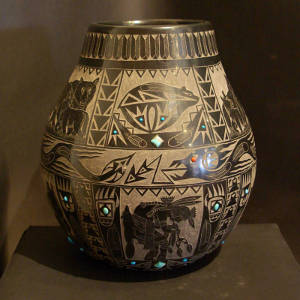 A mix of Sioux and Santa Clara sgraffito designs plus inlaid turquoise decorate a polished black jar