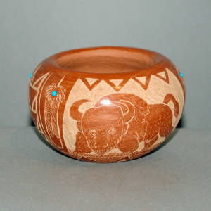Sgraffito buffalo and Sioux design plus inlaid stones on a red jar