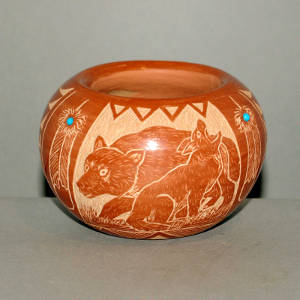 Sgraffito bear, wolf and Sioux design on a red jar with inlaid stones