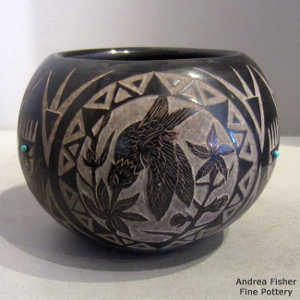 Sgarffito animal and geometric design on a black jar with inlaid stones