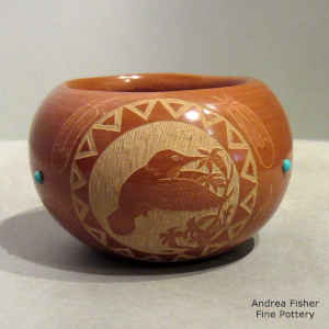 Red jar decorated with a sgraffito hummingbird, feather, flower and geometric design plus inlaid stones