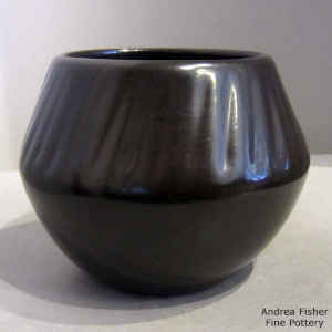 A black jar with melon ribs above the shoulder