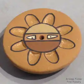 Sun face design on a miniature polychrome seed pot