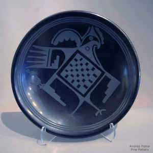 Black on black plate with stylized rooster and geometric design
