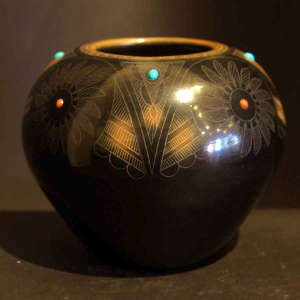 Sgraffito medallion and geometric design on a polished black jar with sienna spots and inlaid coral and turquoise