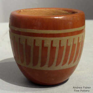 Green feather design on a red jar