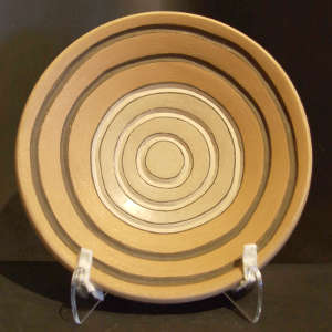Carved and painted circle design on a shallow buff bowl