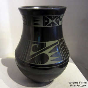 A micaceous slip around the bottom of this green on black jar with a feather and geometric design