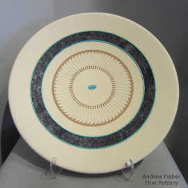 Sgraffito feather and geometric design with a band of black micaceous clay on a buff-colored plate
