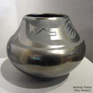 An avanyu design on a black on gunmetal black jar