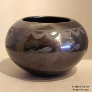 Cloud, tadpole and geometric design on a black on black jar