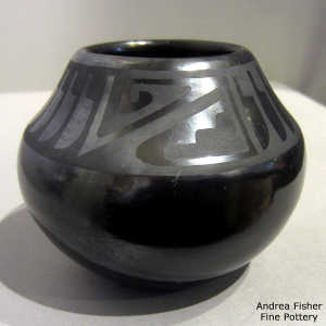 Feather and geometric design on a black on black jar