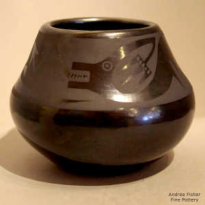 An avanyu design on a black on black jar