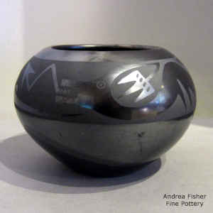 An avanyu design on a black on gunmetal black jar