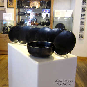 1 bowl and 6 plates in a plain black salad set