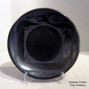 An avanyu and geometric design on a black on black plate