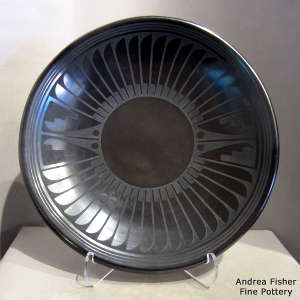 Ring of feathers and geometric design on a black on black plate