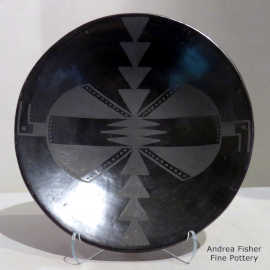 Bird element and geometric design decorate a black-on-black plate