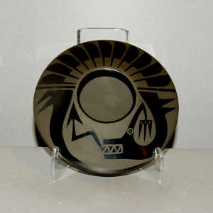 An avanyu design on a black on black jar