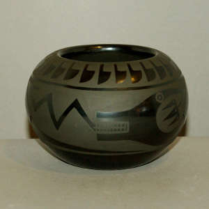 An avanyu design on a black on black jar