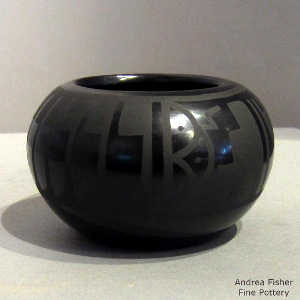 Feather, clouds and geometric design on a black on black jar