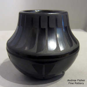 Feather and geometric design on a black on black jar