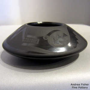 Avanyu, clouds and geometric design on a black on black flying saucer jar