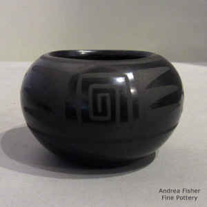 A feather and geometric design on a black on black jar