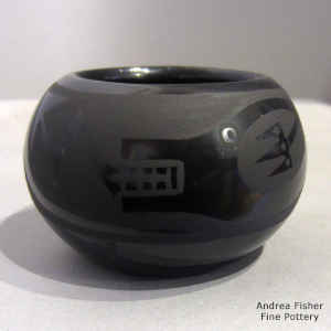 An avanyu design on a black on black jar